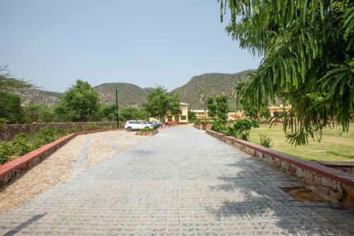 a long road with a car parked on the side at Ratan Villas Sariska in Alwar