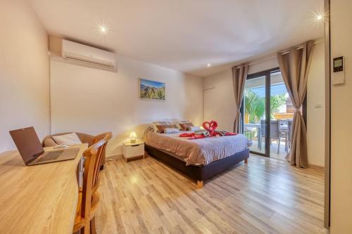 una camera da letto con un letto e una scrivania con un computer portatile di Villa Castors - 3 étoiles - 8 Voyageurs - Piscine chauffée a Saint-Pierre