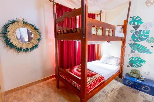 a bedroom with a bunk bed with a mirror at Acacia Villa Kampala in Kampala