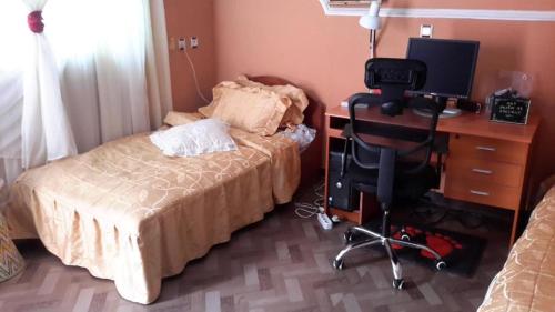 a bedroom with a bed and a desk with a computer at Birhan Villa in Addis Ababa