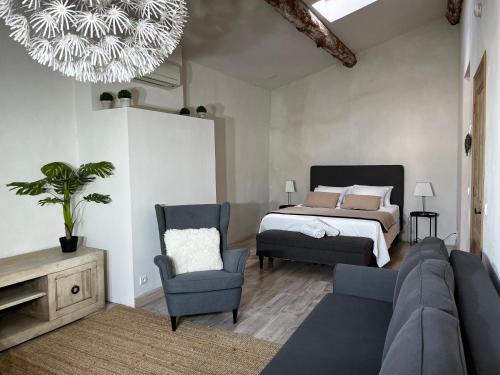 a bedroom with a bed and a couch and a chair at La Cité Secrète in Carcassonne