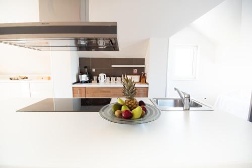 a kitchen with a bowl of fruit on a counter at Milic Apartments - by the sea in Sutivan