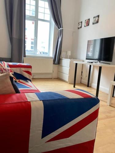 a room with a red white and blue bed with a television at Large Modern Spacious House 6 Bedrooms 5 Bathrooms in London