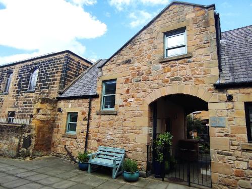 a stone building with a bench in front of it at Dodds Nook in Alnwick