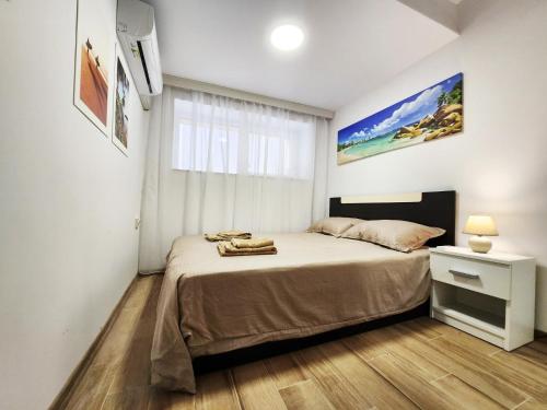 Apartment in the city of Varna في مدينة فارنا: غرفة نوم بسرير ونافذة كبيرة