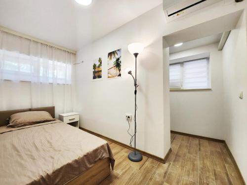 Apartment in the city of Varna في مدينة فارنا: غرفة نوم فيها سرير ومصباح