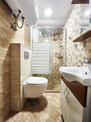 Apartment in the city of Varna في مدينة فارنا: حمام مع مرحاض ومغسلة ودش