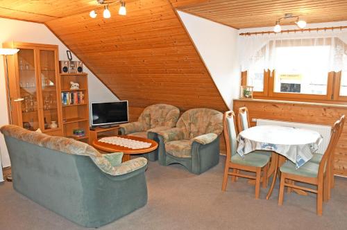 een woonkamer met banken en een tafel en stoelen bij Jasmunder Ferienwohnung in Sagard