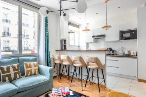 un salon avec un canapé et une cuisine dans l'établissement Modern & Cosy flat - 4 guests near Eiffel Tower, à Paris