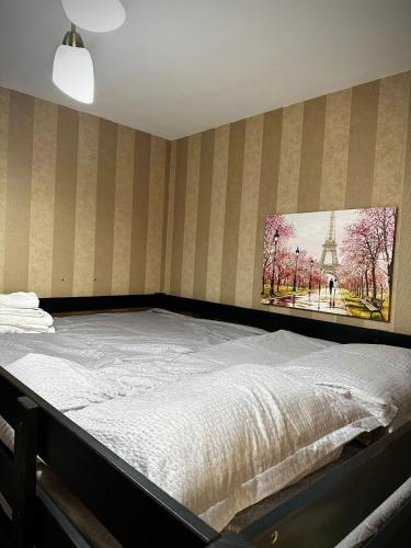 Una cama en una habitación con un cuadro en la pared. en Old Town Central Studio, en Brasov
