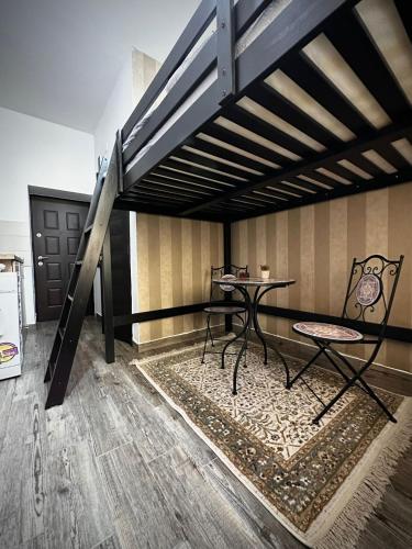 Una cama alta con una mesa y sillas en una habitación. en Old Town Central Studio, en Brasov
