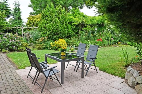 un patio con mesa y 4 sillas en Jasmunder Ferienwohnung, en Sagard