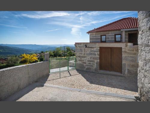 a stone house with a wooden door on a patio at Casa da Costa in Melgaço