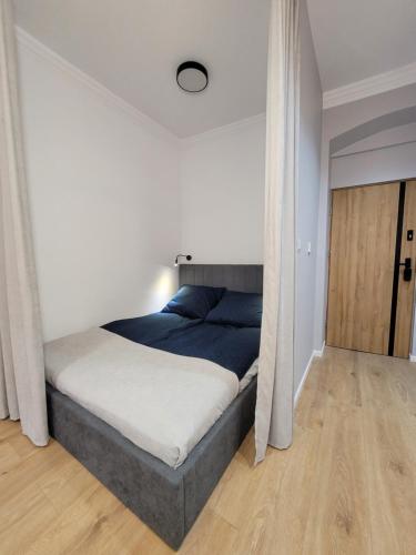 een slaapkamer met een bed met een blauwe deken bij Apartament Sztolnia in Kowary