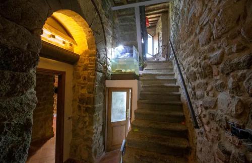 a staircase in a stone building with a door at Elettra Flower Roccia in Montecatini Val di Cecina