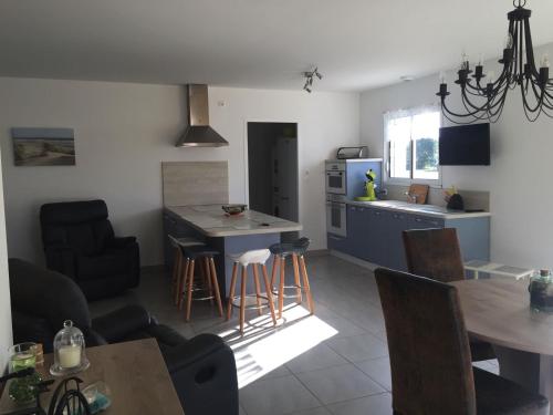 une cuisine et un salon avec une table et des chaises dans l'établissement Maison à Longeville-sur-Mer : Plage, Surf et Détente - FR-1-336-109, à Longeville-sur-Mer