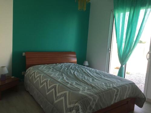 - une chambre avec un lit avec un mur vert et une fenêtre dans l'établissement Maison à Longeville-sur-Mer : Plage, Surf et Détente - FR-1-336-109, à Longeville-sur-Mer