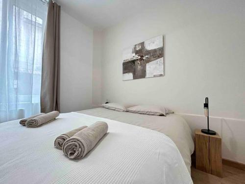 - une chambre blanche avec 2 lits et des serviettes dans l'établissement Nouvel Appartement cosy centre-ville, à Épernay