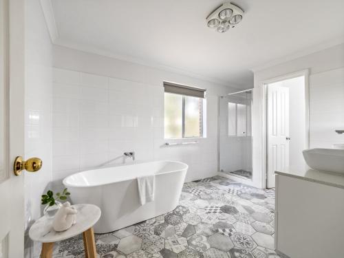 a white bathroom with a tub and a sink at Beachfront Bliss, waterfront Geographe bay in Busselton