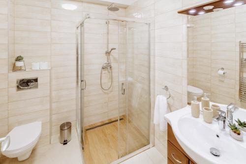 a bathroom with a shower and a toilet and a sink at Elina Apartman in Keszthely