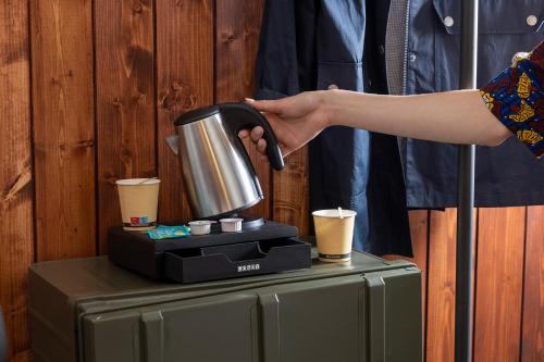 a person holding a coffee pot on top of a table at Best Western Plus Hotel Cargo in Dunkerque
