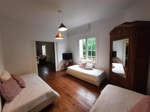 een woonkamer met 2 bedden en een spiegel bij Maison Anglet, 7 pièces, 11 personnes - FR-1-239-860 in Anglet