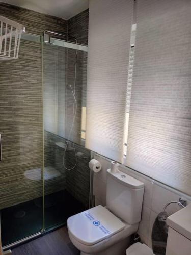 a bathroom with a toilet and a glass shower at Apartamento El Hidalgo in Alcalá de Henares