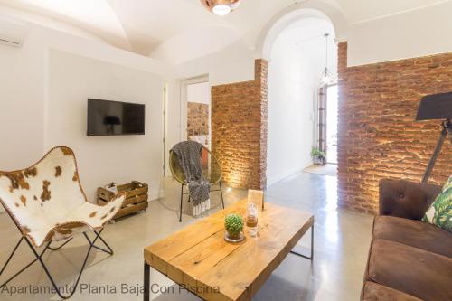 a living room with a brick wall and a table and chairs at Apartamentos Durán Pizarro 1930 in Merida