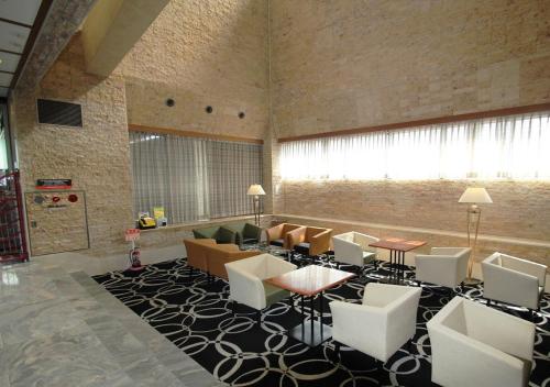a lobby with a couch and chairs in a room at APA Hotel Kanazawa-Nomachi in Kanazawa