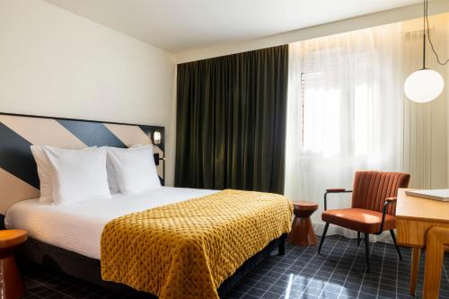 a hotel room with a bed and a desk at Best Western Plus Hotel Cargo in Dunkerque