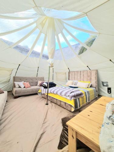 a bedroom in a tent with a bed and a table at Hermoso Glamping en Quinta Privada in Quito
