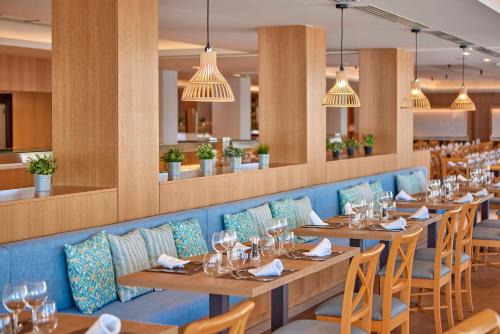 a dining room with wooden tables and chairs at Universal Hotel Lido Park & Spa in Paguera