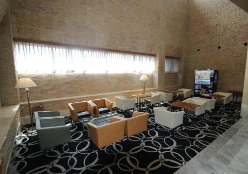 Habitación con sillas, mesas y una ventana grande. en APA Hotel Kanazawa-Nomachi, en Kanazawa