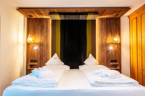 a bedroom with two beds with towels on them at Moseralm Dolomiti Spa Resort in Nova Levante