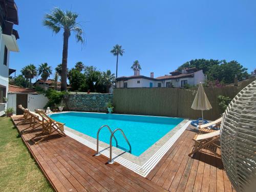 a swimming pool in a backyard with a wooden deck at La Sorella in Dalyan