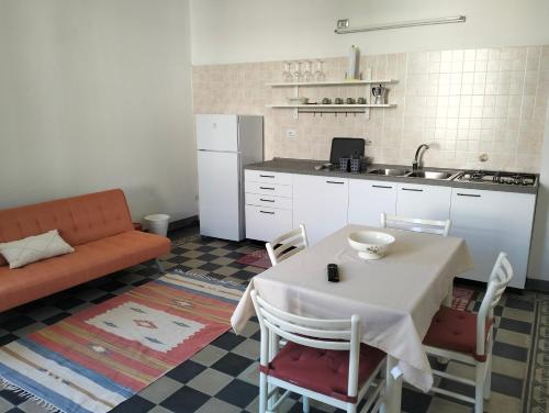 uma cozinha com uma mesa e uma cozinha com um sofá em Casa degli Ulivi em Salò