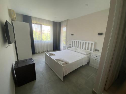 a bedroom with a white bed and a window at La Sorella in Dalyan