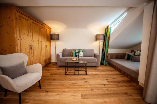 a living room with a couch and a chair at Moseralm Dolomiti Spa Resort in Nova Levante