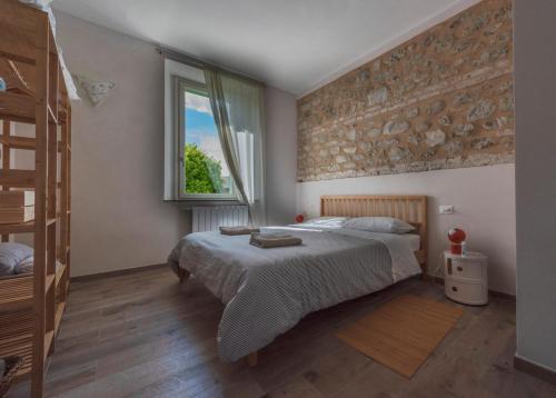 um quarto com uma cama grande e uma janela em Il Giardino di Marzo Guest House em Monti di Licciana Nardi