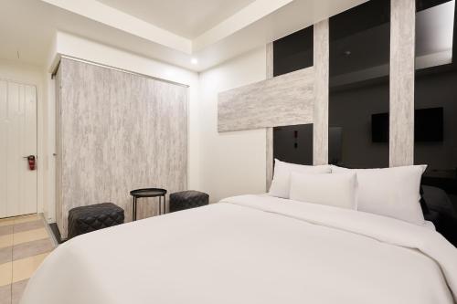 a bedroom with a large white bed and a window at Show Hotel in Pyeongtaek