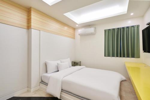 a white bedroom with a white bed and a window at Show Hotel in Pyeongtaek