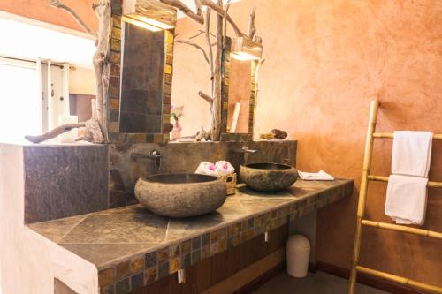 a bathroom with two stone sinks on a counter at Villa Laurina in Saint-Paul
