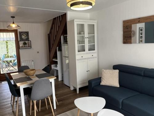 un salon avec un canapé bleu et une table dans l'établissement **Cottage 6 pers à Cabourg - Proche plage et thalasso, jardin, parking, Wi-Fi gratuit** - FR-1-487-358, à Cabourg