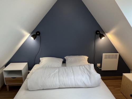 - une chambre avec un lit blanc et un mur bleu dans l'établissement **Cottage 6 pers à Cabourg - Proche plage et thalasso, jardin, parking, Wi-Fi gratuit** - FR-1-487-358, à Cabourg