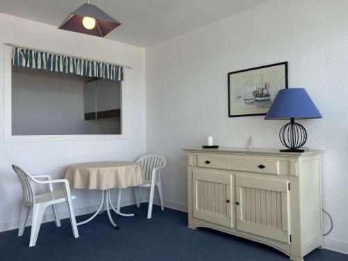 Cette chambre comprend une table, une table et des chaises. dans l'établissement Appartement 1 pièce face mer avec terrasse à La Baule – 2 couchages - FR-1-245-188, à La Baule