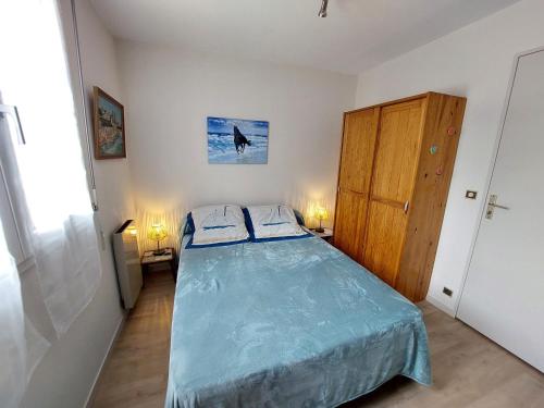 une petite chambre avec un lit et une porte en bois dans l'établissement Charmant T2 au cœur de Saint-Palais-sur-Mer, à deux pas du marché et de la plage - FR-1-550-66, à Saint-Palais-sur-Mer