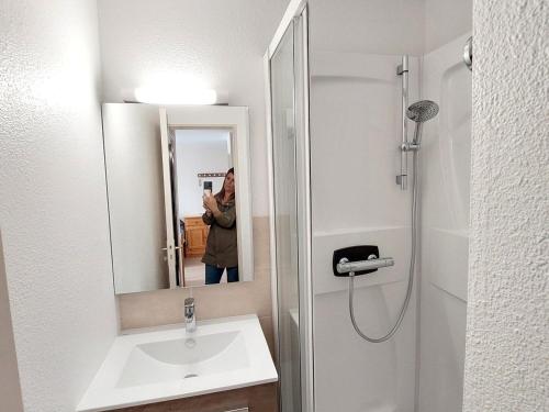 une personne prenant une photo dans un miroir de salle de bains dans l'établissement Charmant T2 au cœur de Saint-Palais-sur-Mer, à deux pas du marché et de la plage - FR-1-550-66, à Saint-Palais-sur-Mer