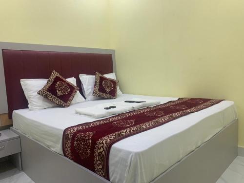 a bedroom with a large bed with red and white pillows at Hotel Sai Plaza, Chembur Mumbai in Mumbai