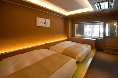 two beds in a small room with a window at Suigan in Jozankei