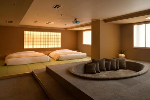 two beds in a large room with a rug at Suigan in Jozankei